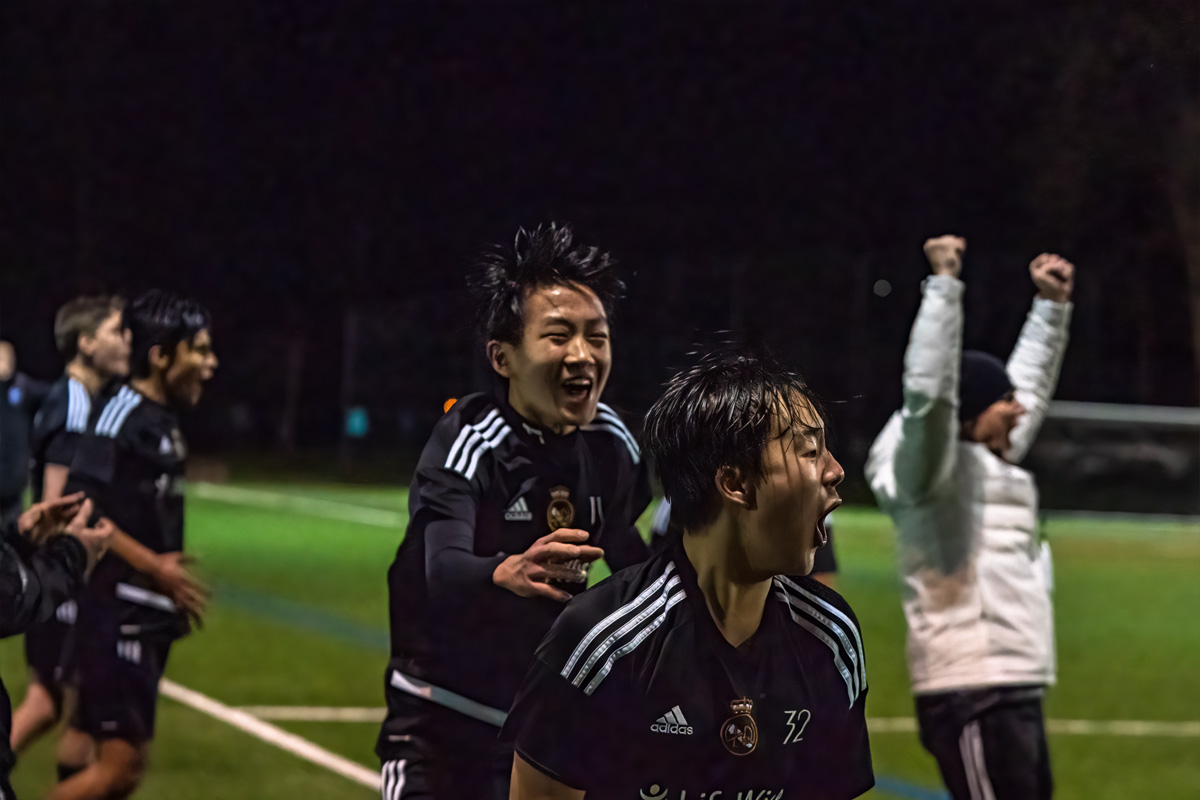 Coach and boys players celebrate the winning goal